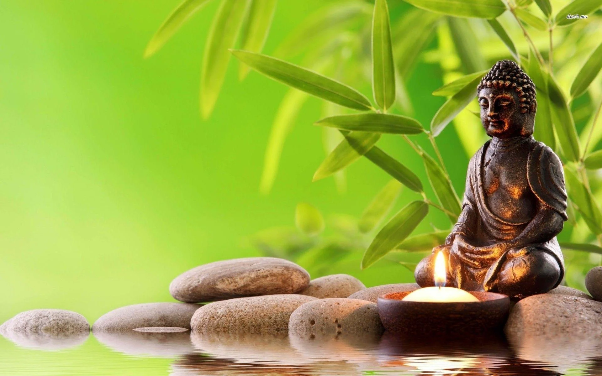 Tượng Phật nhỏ bên nến và đá cuội tạo không gian tĩnh lặng trong chủ đề hình ảnh phật